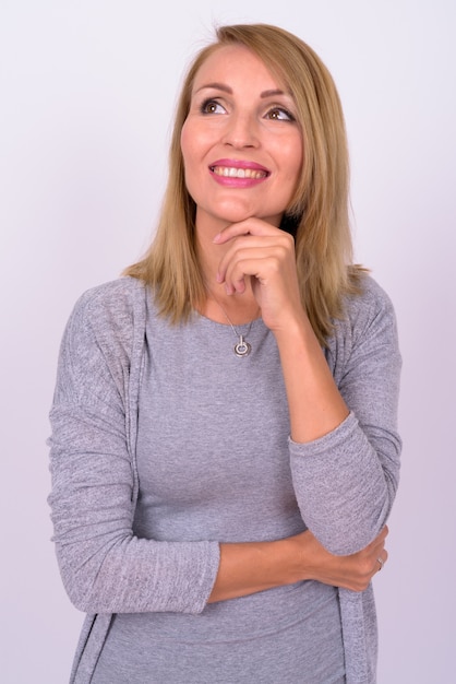 beautiful businesswoman with blond hair against white wall