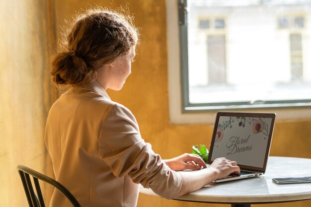 Beautiful businesswoman working on her laptop at a cafe