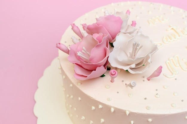 Beautiful cake decorated with roses on wooden table Homemade