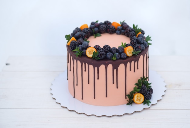 Beautiful cake in winter style with fir branches and natural berries