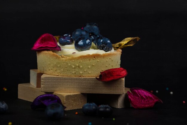 A beautiful cake with blueberries on a dark wooden background