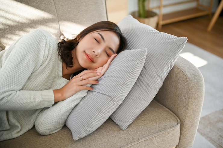 Photo 아름답고 조용하고 평화로운 아시아 여성이 거실에서 낮잠을 자거나 소파에서 자고 있습니다.