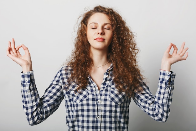 Beautiful calm young woman keeps eyes shit