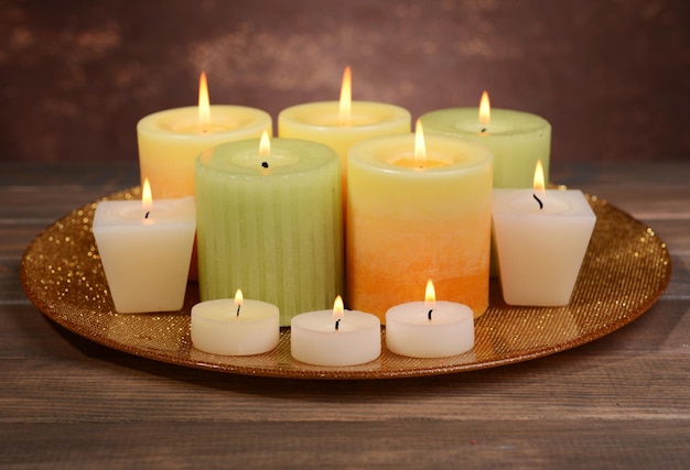 Beautiful candles on table on brown background