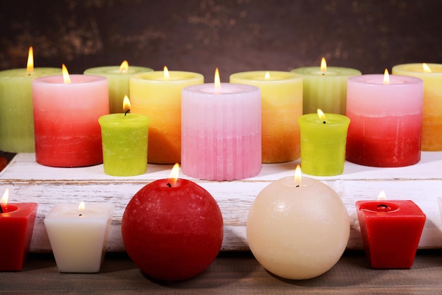 Beautiful candles on table on brown background