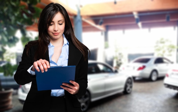 Beautiful car dealer reading a contract