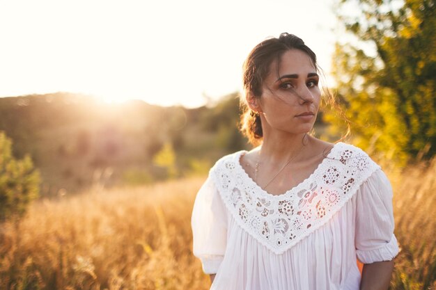 Beautiful carefree woman in fields being happy outdoors