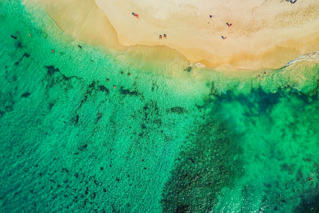 ドミニカ共和国の美しいカリブ海のビーチ人々の海岸と白い砂浜の小さな人物と熱帯の牧歌的な夏の風景の空中抽象ビュー