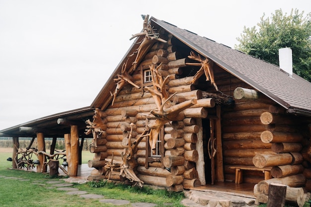 Красивый резной деревянный дом в деревне из бревен и скотных дворов