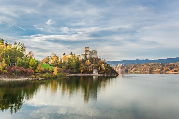 Beautiful castle by the lake at sunset in autumn