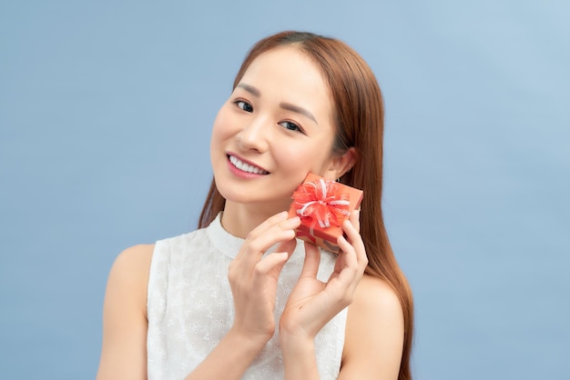 Beautiful casual woman holding small present in hands