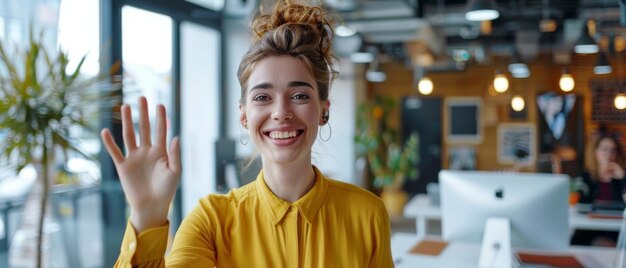 Foto bella specialista donna caucasica che saluta un collega durante una chiamata in diretta in un ambiente di ufficio creativo bella giovane project manager che fa una videochiamata