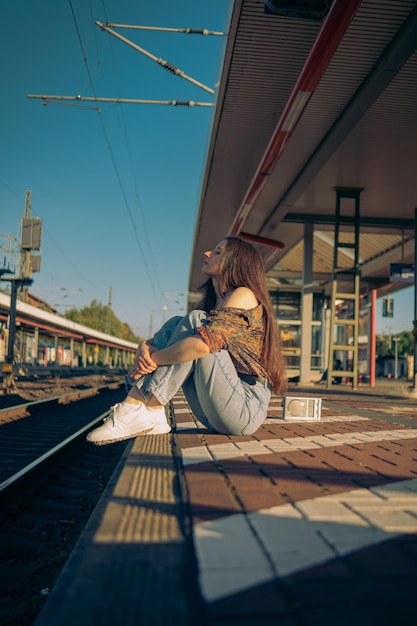 Foto bella ragazza caucasica in posa sulla piattaforma ferroviaria