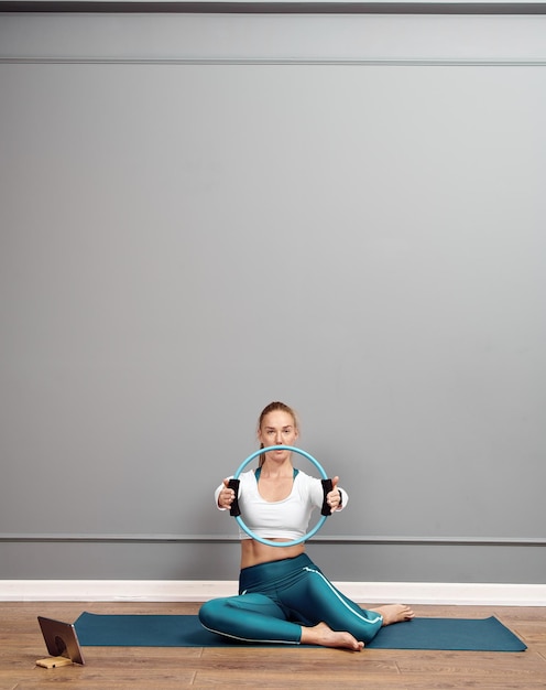 Beautiful caucasian girl working out at home. Brunette girl in squat position working out glutes.