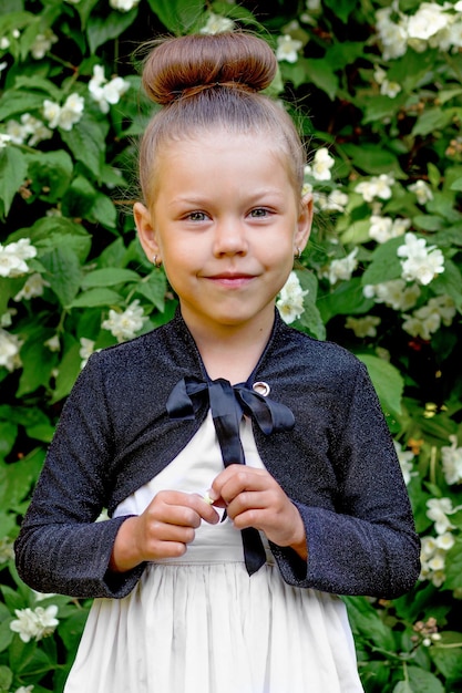 Beautiful caucasian little girl of 5 years old looking at camera on trees background