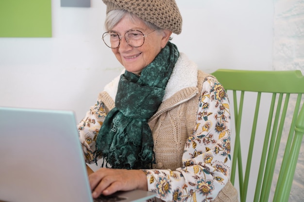 Beautiful caucasian senior woman sitting with netbook in cafe charming female using laptop computer during rest in coffee shop