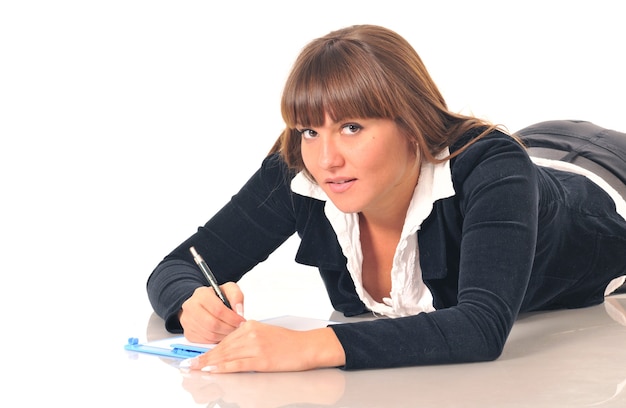 Beautiful caucasian white brunette woman lying holding pen and take a note in the notebook