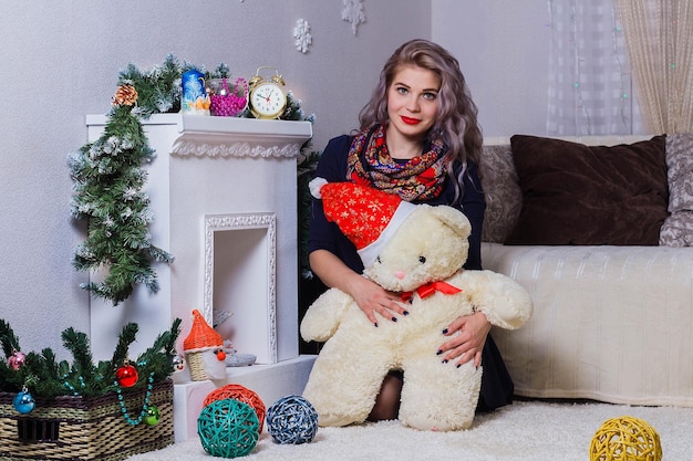 Beautiful Caucasian woman posing on fireplace background Christmas and new year mood