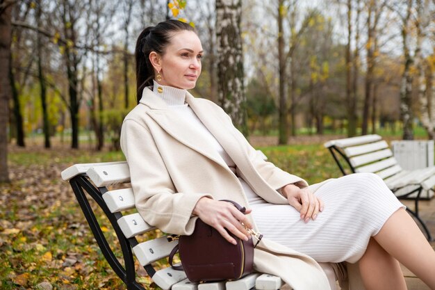 Beautiful caucasian woman sitting on a bench in the park