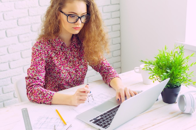 Beautiful caucasian woman sitting and working on laptop