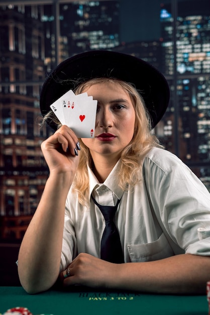 Beautiful Caucasian woman with poker cards near her face covering herself