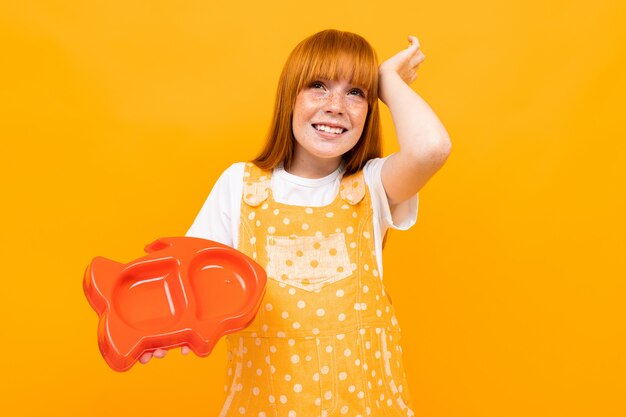 Beautiful caucasian woman with red hair forgot to feed the pet on yellow