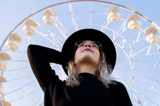 Foto bella donna caucasica con occhiali cornice alla moda all'aperto.