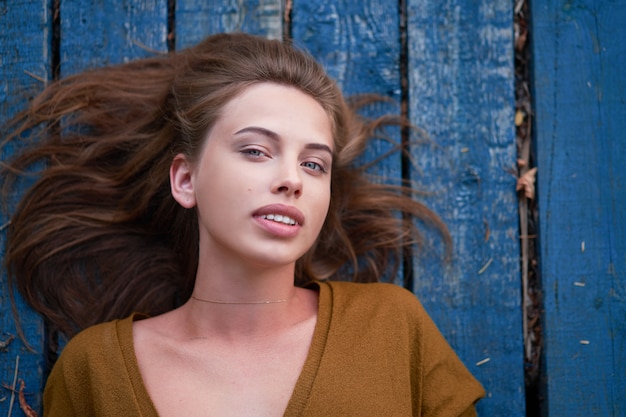 Beautiful caucasian young woman lying on wooden pier