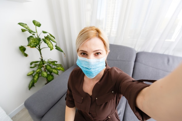 Beautiful caucasian young woman with disposable face mask. Protection versus viruses and infection.