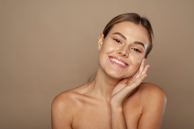 Bella giovane donna caucasica con il viso commovente della pelle perfetta.