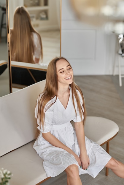 beautiful charming woman in a light summer dress in an apartment festive mood