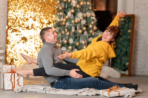 A beautiful cheerful couple greets the Christmas holidays in a cozy home atmosphere