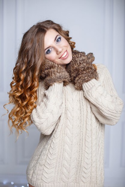 Bella ragazza allegra con un sorriso incredibile in un maglione caldo e guanti