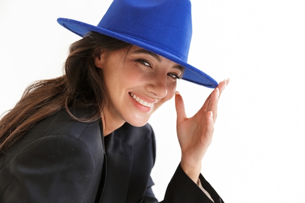 孤立したポーズの青い帽子の美しい陽気な楽観的な幸せな女性。