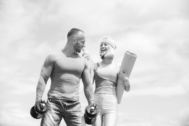 Foto allenamento di bella donna sorridente allegra con la sua coppia di innamorati di allenatore sportivo che fa fitness al fresco e...