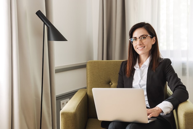 beautiful cheerful young business woman in formal wear clothes indoors at home work with laptop computer.