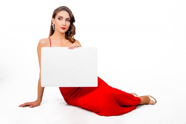 Beautiful chic woman in red long dress with a sheet of paper in hands
