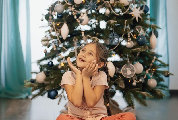 Beautiful child girl near a Christmas tree. Christmas concept.