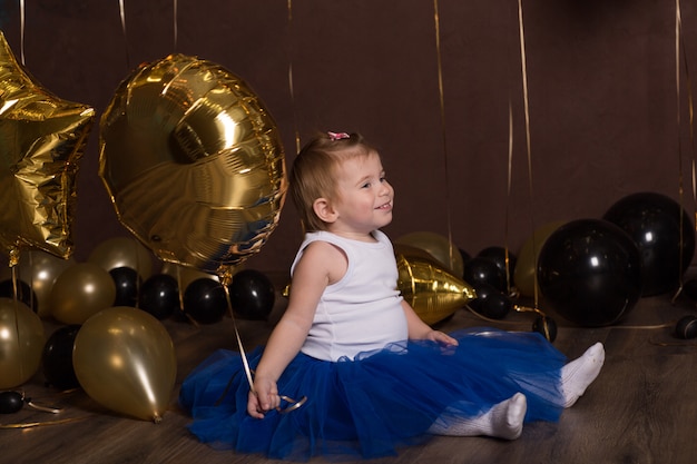 Beautiful child sitting with the ball. pretty face. A cute littl