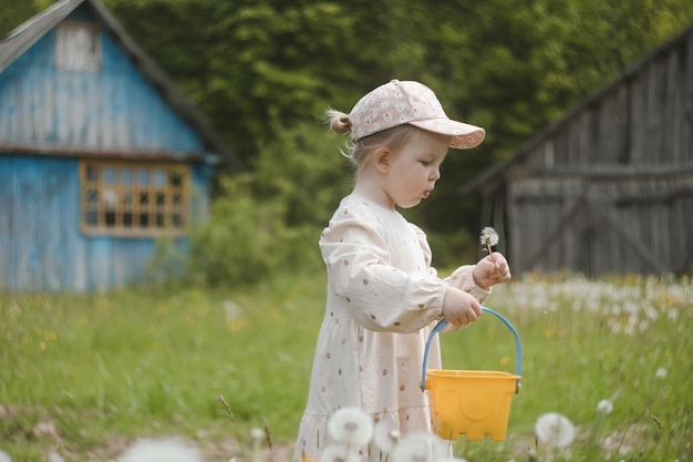 夏の公園でタンポポの花を持つ美しい子供屋外で楽しんで幸せな子供