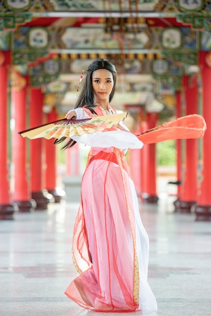사진 그녀의 손에 타격 전통적인 양복과 아름 다운 중국 여자.