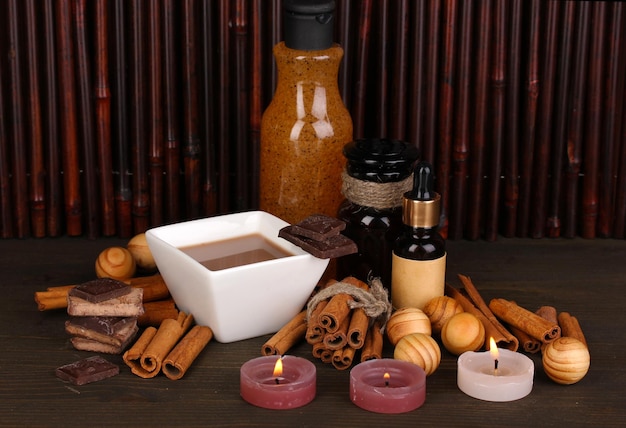 Beautiful chocolate spa setting on wooden table bamboo background with reflection