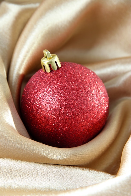 Beautiful Christmas ball on golden satin cloth