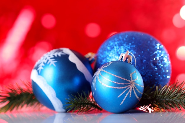 Beautiful Christmas balls on red blurred background