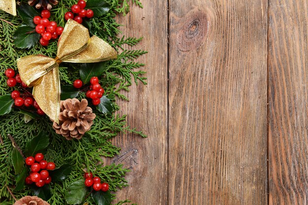 Bellissimo bordo natalizio di abete e vischio su fondo in legno