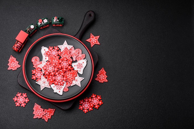 A beautiful christmas composition consisting of ceramic plates gingerbread and other elements of new year's decorations on a dark concrete background