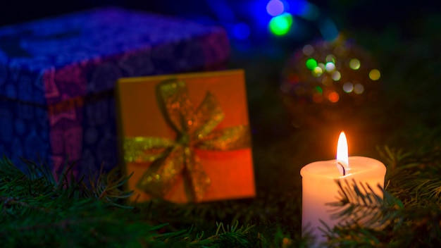 Красивая рождественская композиция с еловыми ветками, свечами, подарочной коробкой и декором