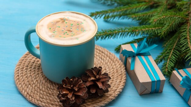 On a beautiful Christmas day, there is coffee with foam and gifts on the table.