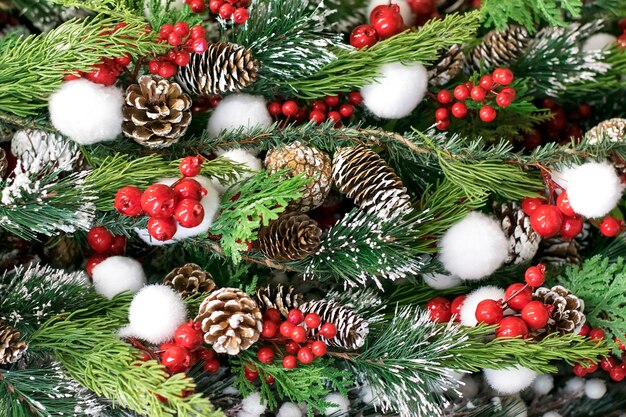 Beautiful Christmas decoration spruce, cones and red snow-covered berries, festive background, wallpaper.