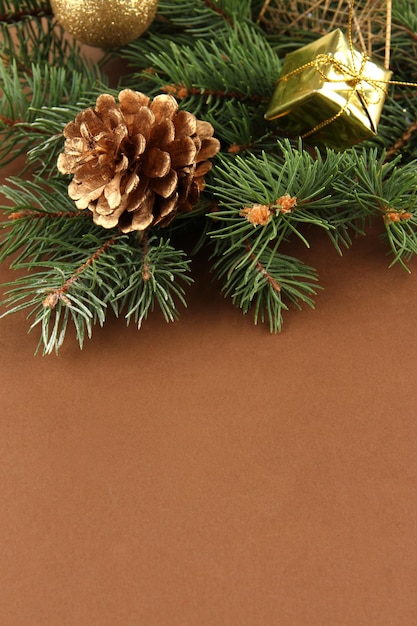 Beautiful Christmas decorations on fir tree on brown background